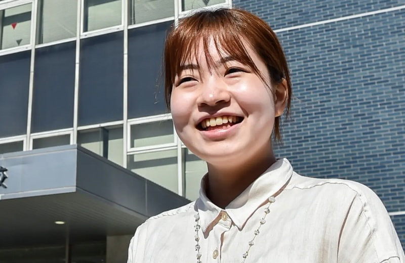 写真：ブラウスを着た笑顔の女子学生