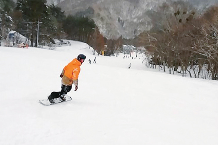写真：雪山でスノーボードをしている竹迫 伸一郎先生