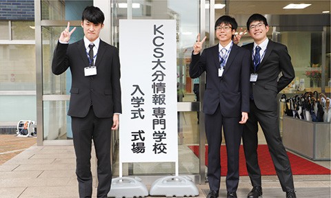 写真：レクリエーションの様子。左側の生徒はお釜からお皿へご飯を盛りつけ、右側の生徒は鍋からご飯の乗ったお皿へカレーを盛り付けている。