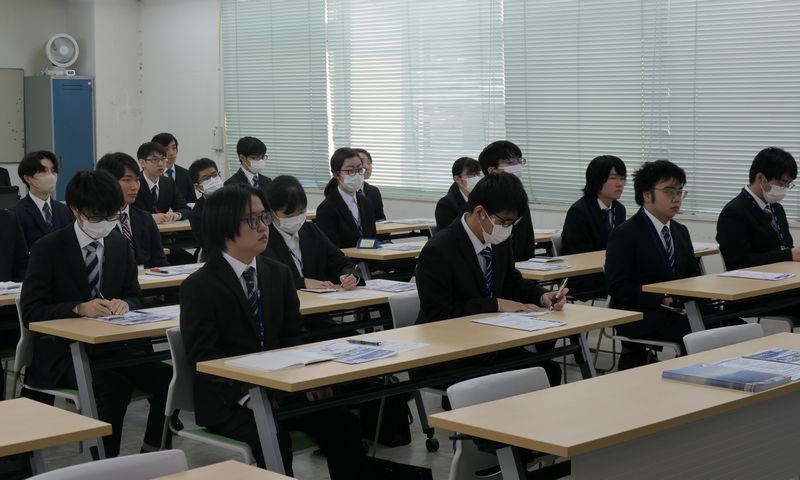 写真：KCS合同企業説明会の様子。スーツを着たたくさんの学生が会場で企業説明を聞いている。