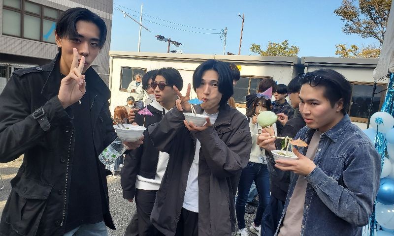 写真：蒼造祭でのバンド演奏の様子。バンドメンバーは6人で、その後ろ側、飾りが付けられたホワイトボードに「蒼造祭」と書かれている。