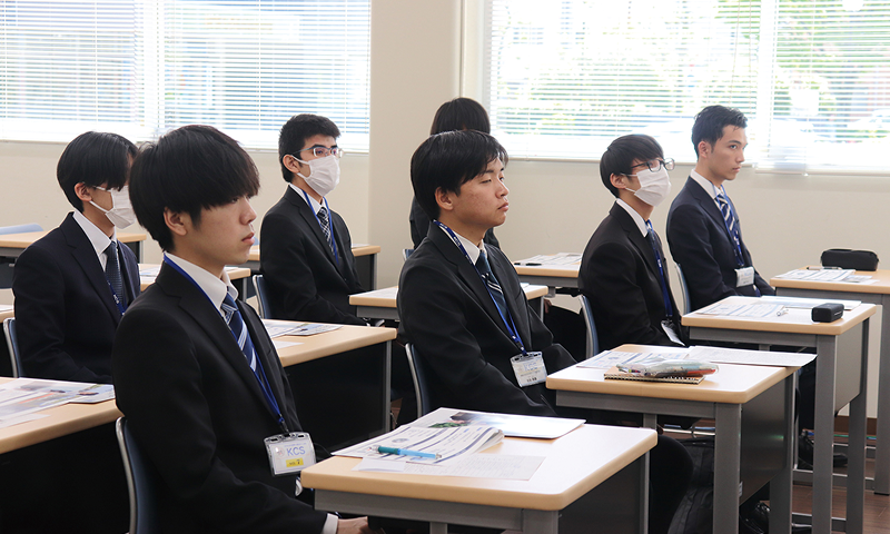 写真：KCS合同企業説明会の様子。スーツを着たたくさんの学生が会場で企業説明を聞いている。